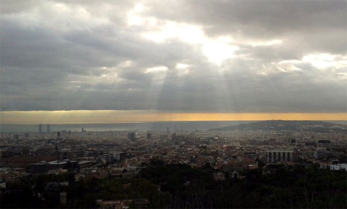 Barcelona vista desde Vallvidrera con el sol de la mañana filtrándose entre las nubes sobre el mar